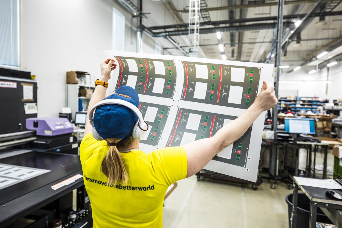 Työntekijä tarkastaa painettuja paneeleja tuotantolinjalla
